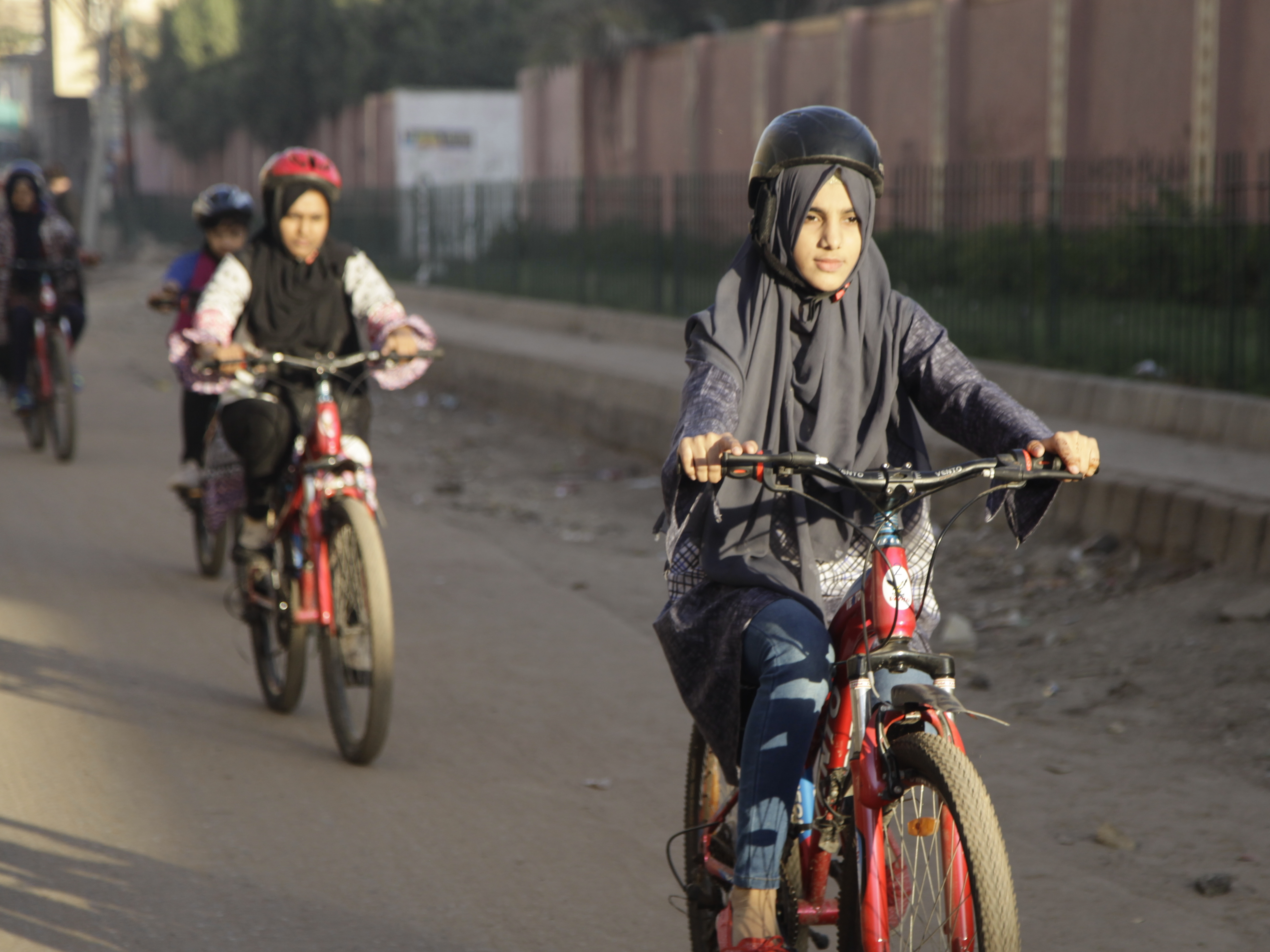 caption: Zulekha Dawood leads a group of female cyclists through a neighborhood in Karachi, Pakistan. They ride early in the morning to avoid the worst of traffic.