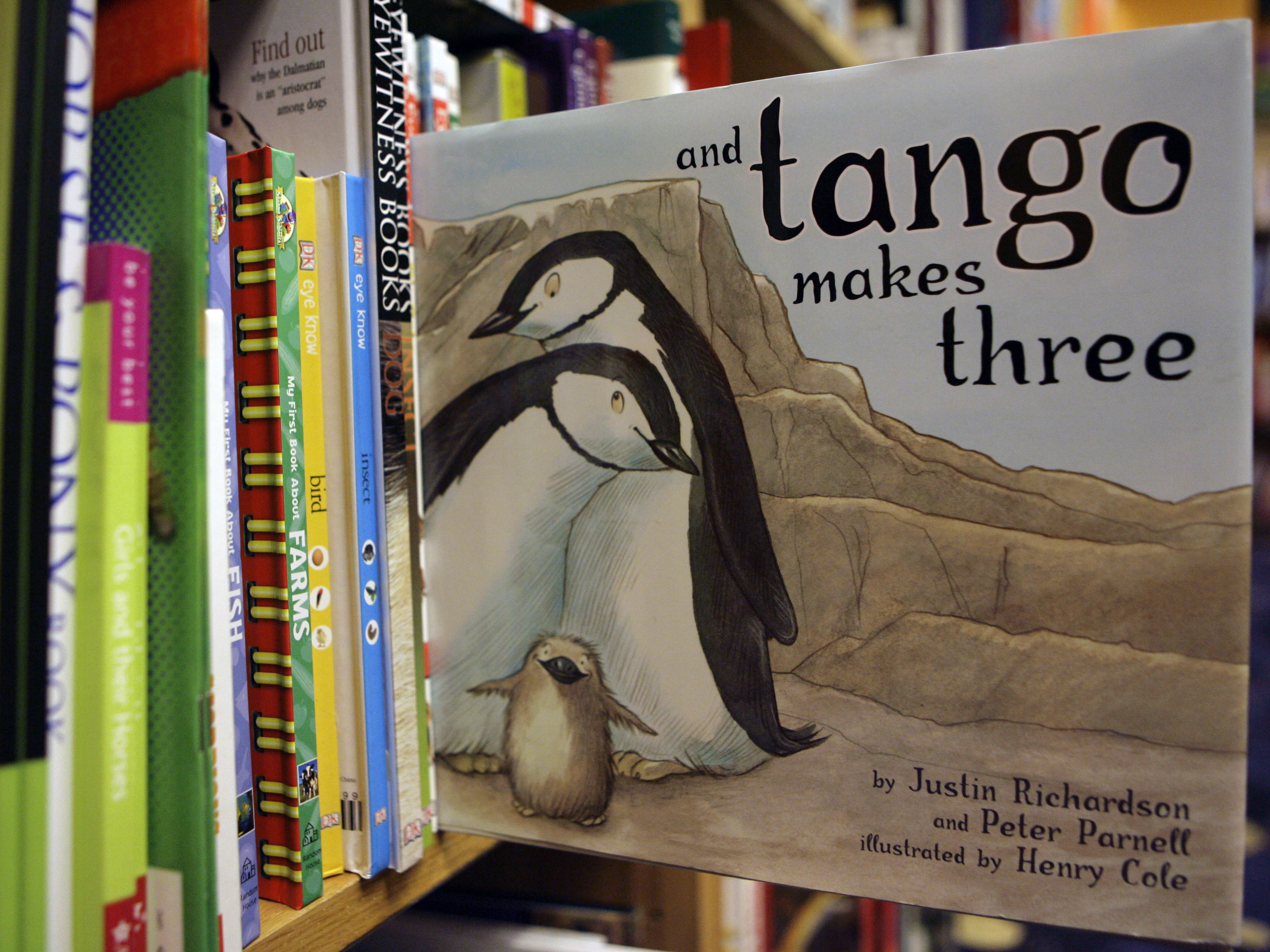 caption: A copy of the book "And Tango Makes Three" is photographed on a bookstore shelf in Chicago in 2006. Months after access to the popular children's book about a male penguin couple hatching a chick was restricted at school libraries, a central Florida school district says it has reversed that decision.