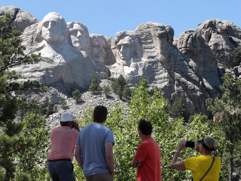 caption: Tourists visit Mount Rushmore National Monument on Wednesday. President Trump is expected to visit the federal monument in South Dakota and give a speech before a fireworks display on Friday.
