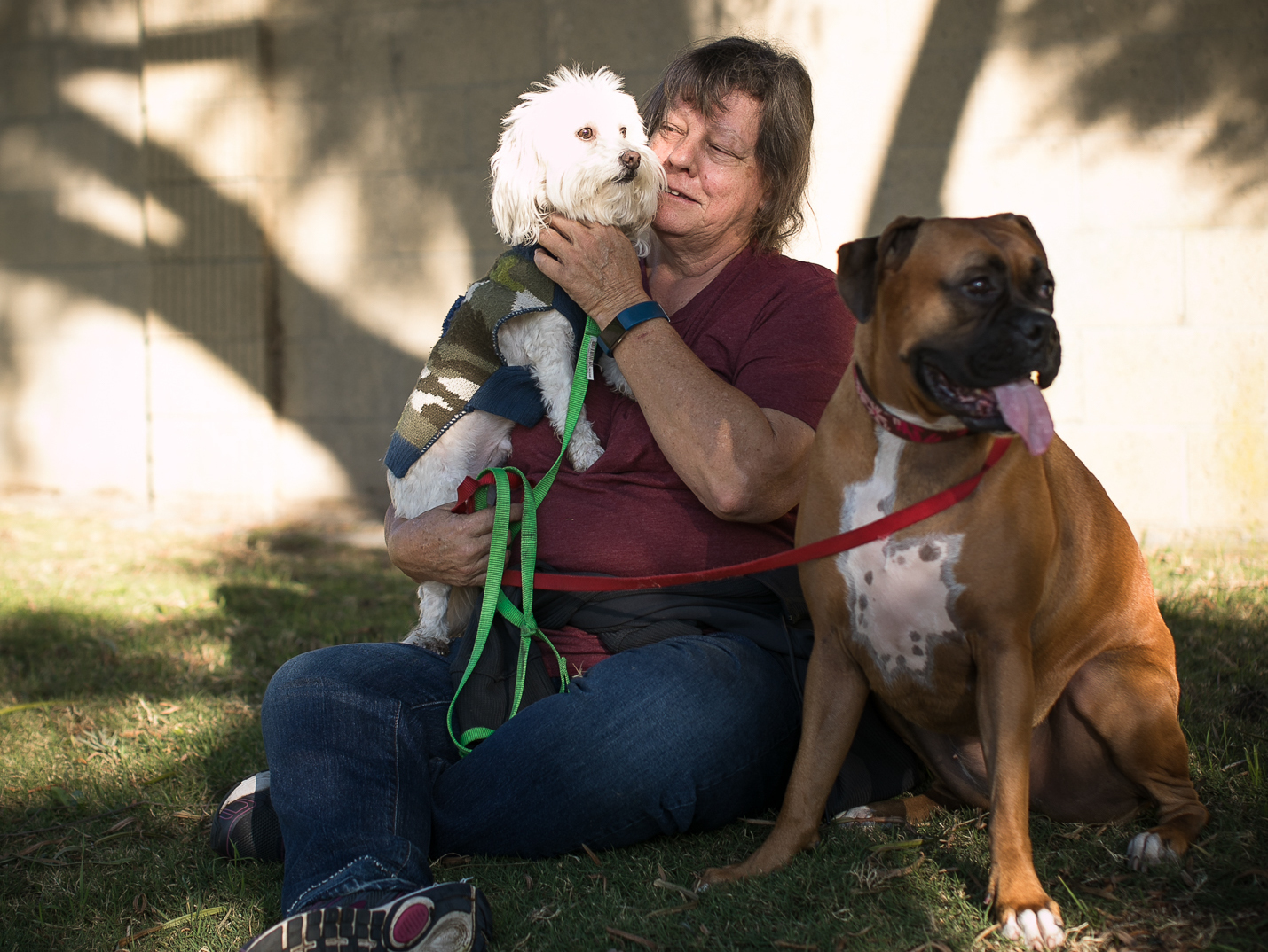 caption: Kathy Klute-Nelson takes a break with her dogs Kona (left) and Max.