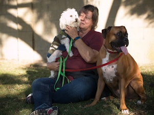 caption: Kathy Klute-Nelson takes a break with her dogs Kona (left) and Max.