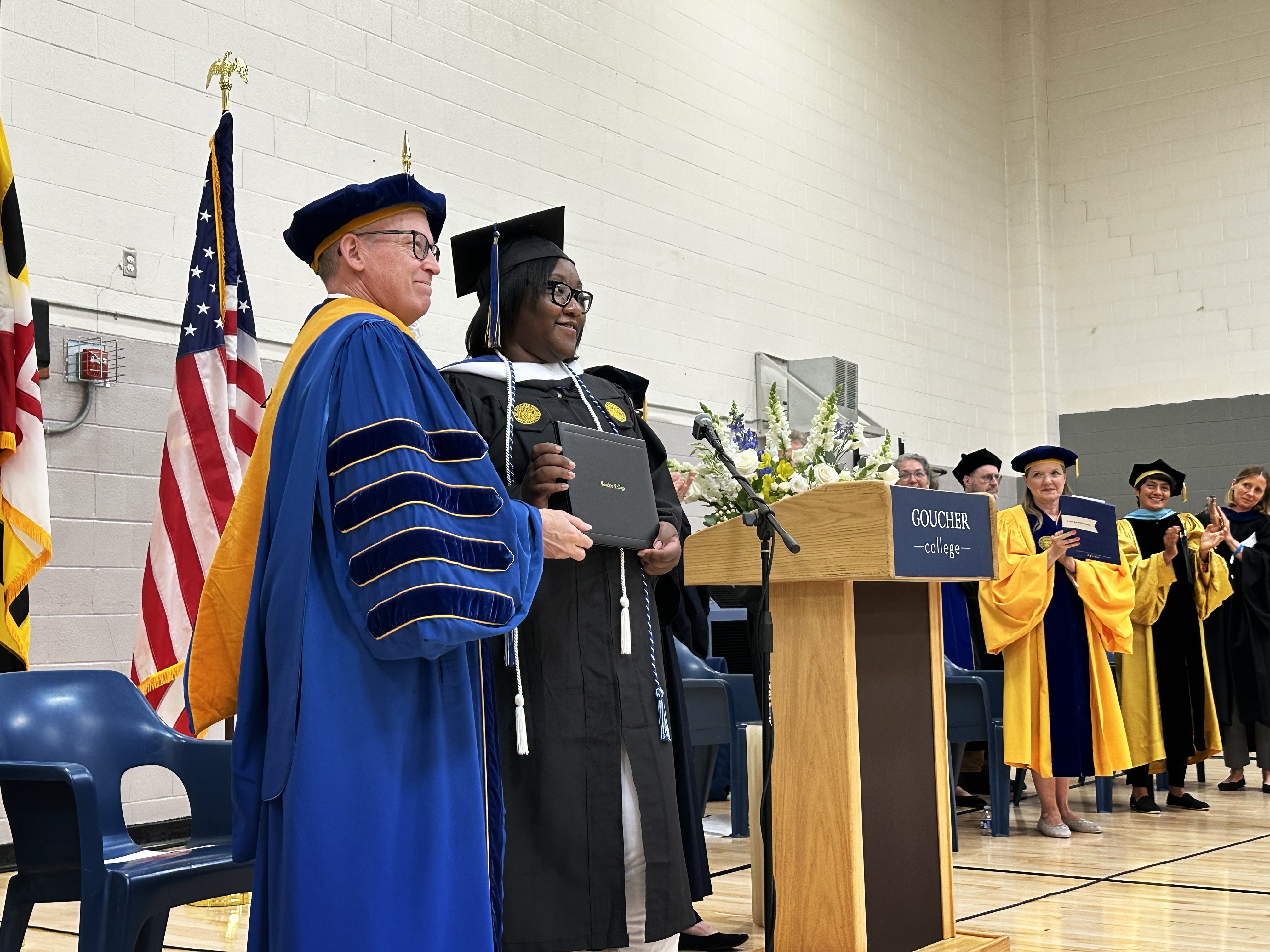 caption: Janet Johnson receives her college diploma from Kent Devereaux, president of Goucher College.