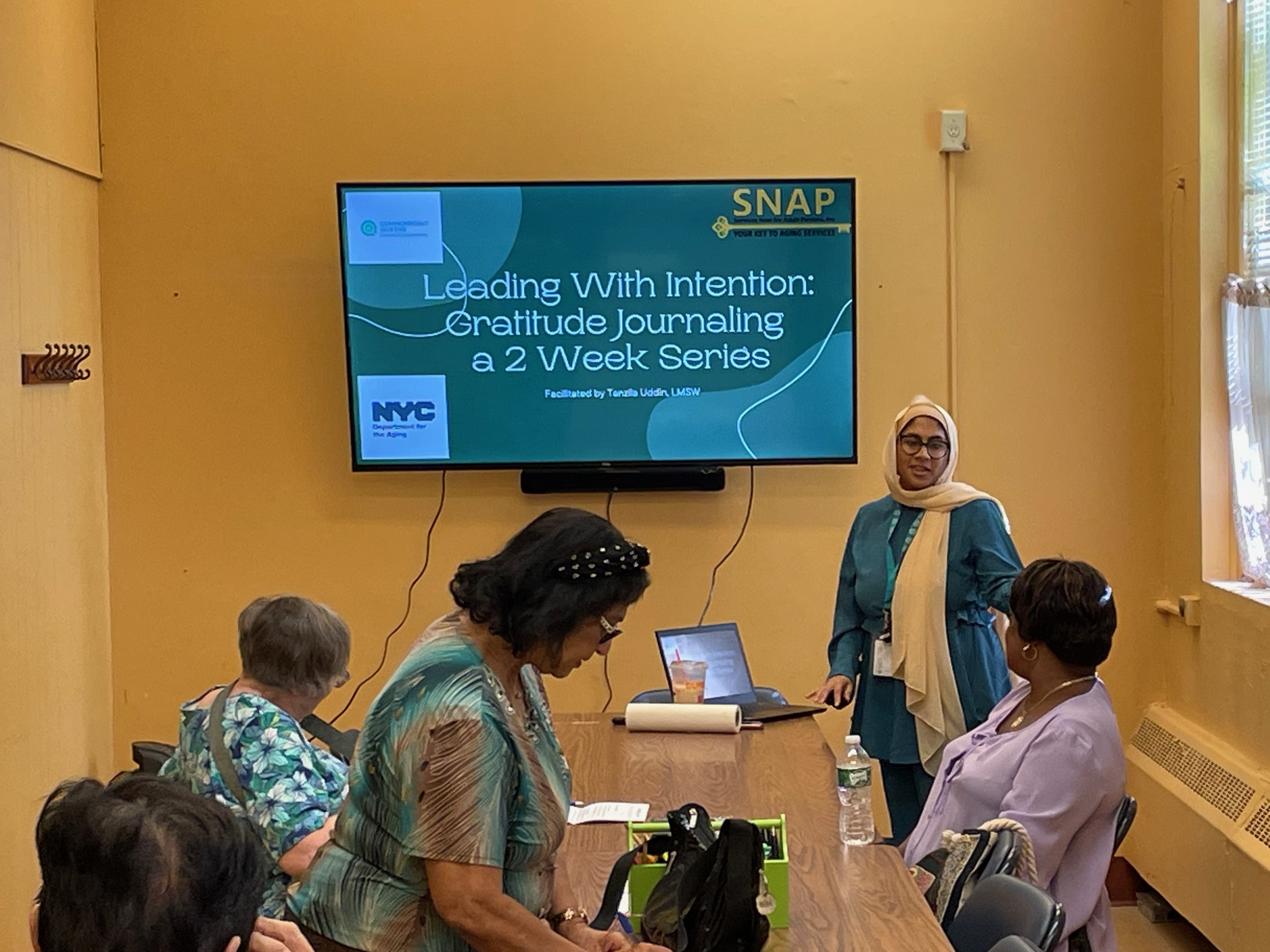 caption: Social worker Tanzila Uddin leads a workshop on journaling at a senior center in Queens Village in NYC. These gatherings can identify older adults who may need more mental health treatment.