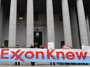 caption: Climate activists protest on the first day of the ExxonMobil trial outside the New York State Supreme Court building on 2019. Last month, prosecutors described how ExxonMobil tried to take advantage of material stolen by hackers working for Aviram Azari.