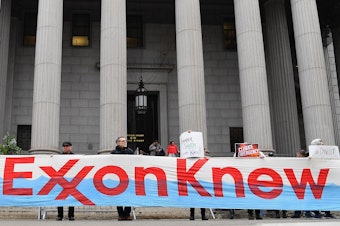caption: Climate activists protest on the first day of the ExxonMobil trial outside the New York State Supreme Court building on 2019. Last month, prosecutors described how ExxonMobil tried to take advantage of material stolen by hackers working for Aviram Azari.
