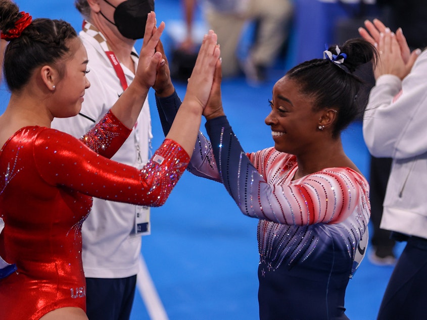 caption: Sunisa Lee and Simone Biles of Team USA during the Women's Balance Beam Final at the Tokyo 2020 Olympic Games in August 2021.