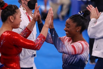 caption: Sunisa Lee and Simone Biles of Team USA during the Women's Balance Beam Final at the Tokyo 2020 Olympic Games in August 2021.