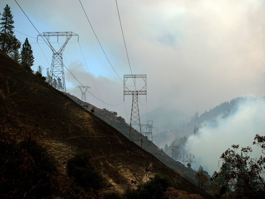 caption: Power lines are seen through smoke from the Camp Fire near Pulga, Calif., on Sunday.