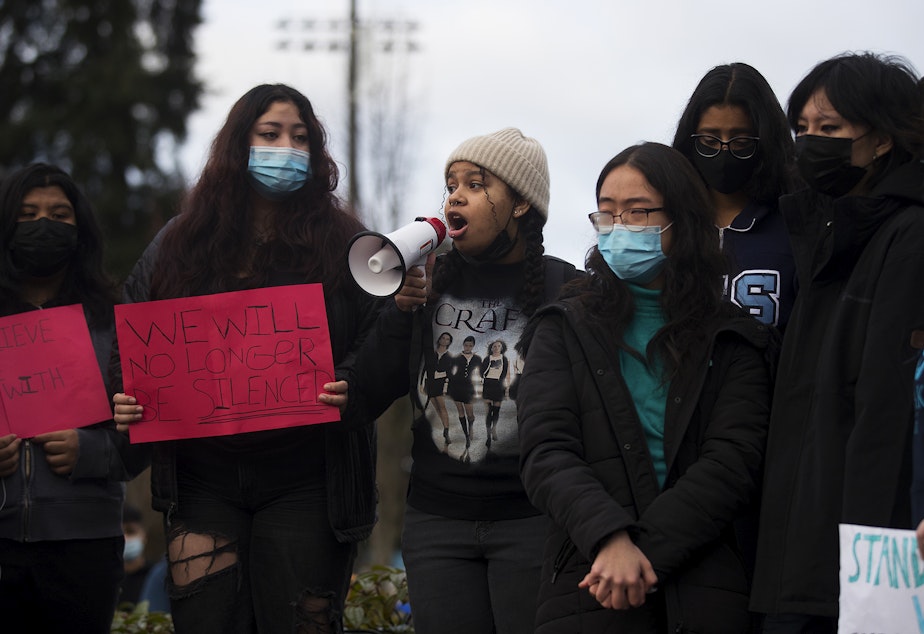 caption: Interlake High School senior Alexa Harris speaks to a crowd of fellow classmates through a megaphone during a protest of the school administration's handling of sexual assault cases, on Tuesday, November 23, 2021, at Interlake High School in Bellevue. "What's actually disrupting class is having to sit next to your fucking rapist," Harris said. 