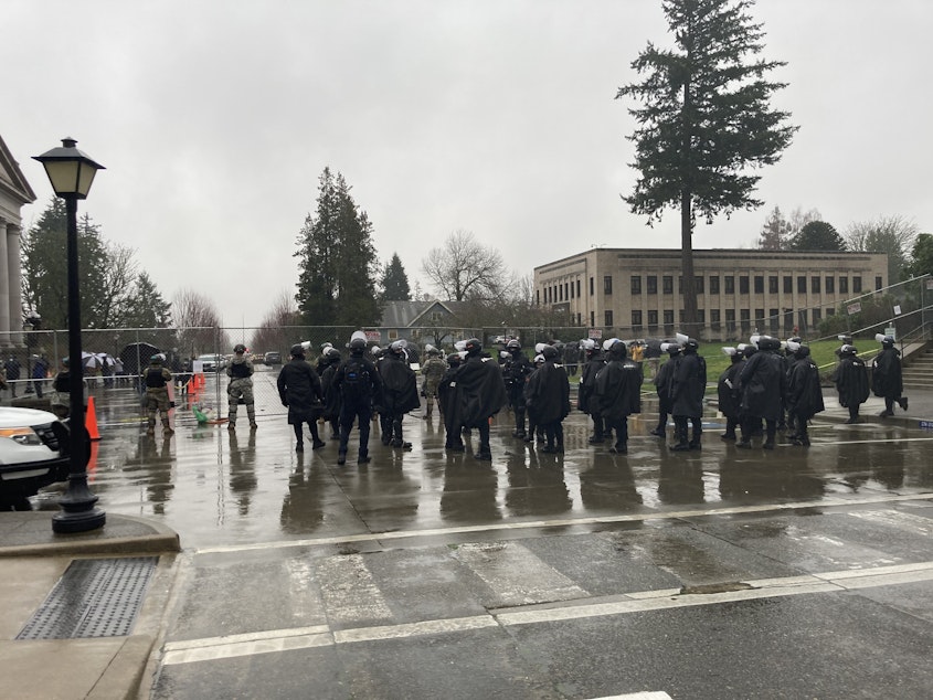 caption: Washington State Patrol troopers and National Guard members protected the state Capitol on the first day of the 2021 legislative session. The unprecedented security followed the January 6 attack on the U.S. Capitol and a major breach that same day at the Governor's residence.