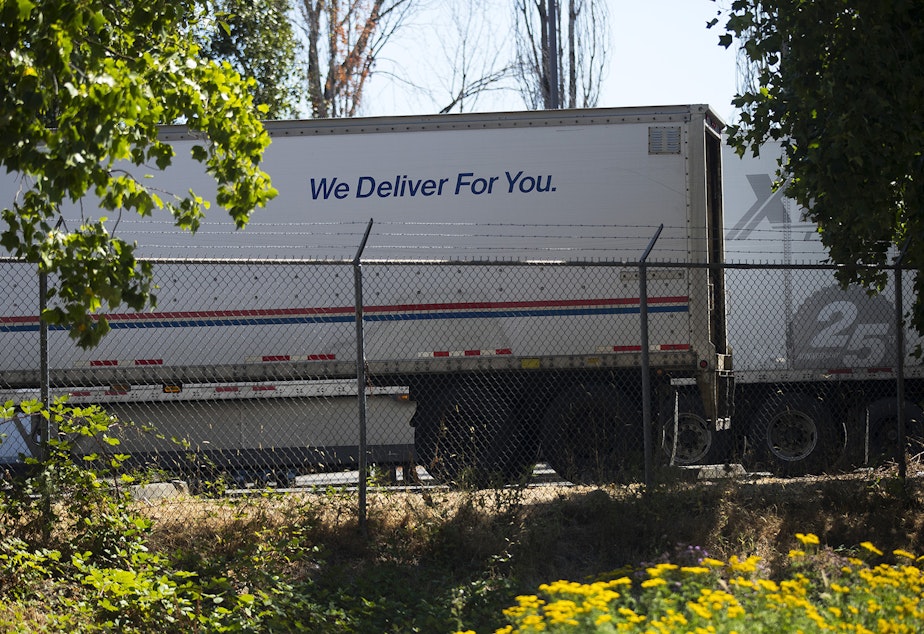 caption: A USPS truck is shown on Monday, August 17, 2020, at a USPS Processing & Distribution Center, one of the 15 facilities in Washington state where high-speed letter sorting machines are to be removed, on 27th Avenue South in Tukwila.