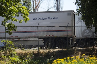 caption: A USPS truck is shown on Monday, August 17, 2020, at a USPS Processing & Distribution Center, one of the 15 facilities in Washington state where high-speed letter sorting machines are to be removed, on 27th Avenue South in Tukwila.