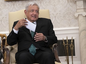 caption: Mexican President Andrés Manuel López Obrador pulls out his remarks in the Oval Office.