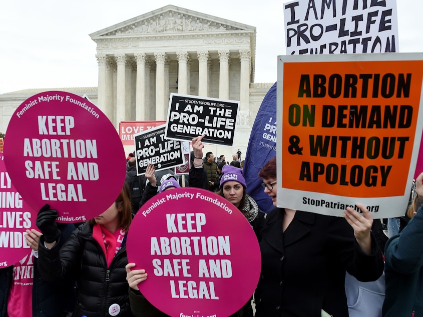 caption: Activists on opposite sides of the abortion debate demonstrate in front of the Supreme Court during the annual anti-abortion-rights event known as the March for Life, on Jan. 24 in Washington, D.C.