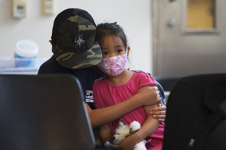 caption: Micah Wong, 10, comforts his younger sister, Vivienne Wong, 5, after they both received the Pfizer Covid-19 vaccine on Wednesday, November 3, 2021, at the UW Medicine North King County Vaccination Clinic in Shoreline. 