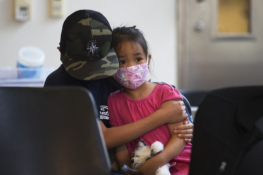 caption: Micah Wong, 10, comforts his younger sister, Vivienne Wong, 5, after they both received the Pfizer Covid-19 vaccine on Wednesday, November 3, 2021, at the UW Medicine North King County Vaccination Clinic in Shoreline.