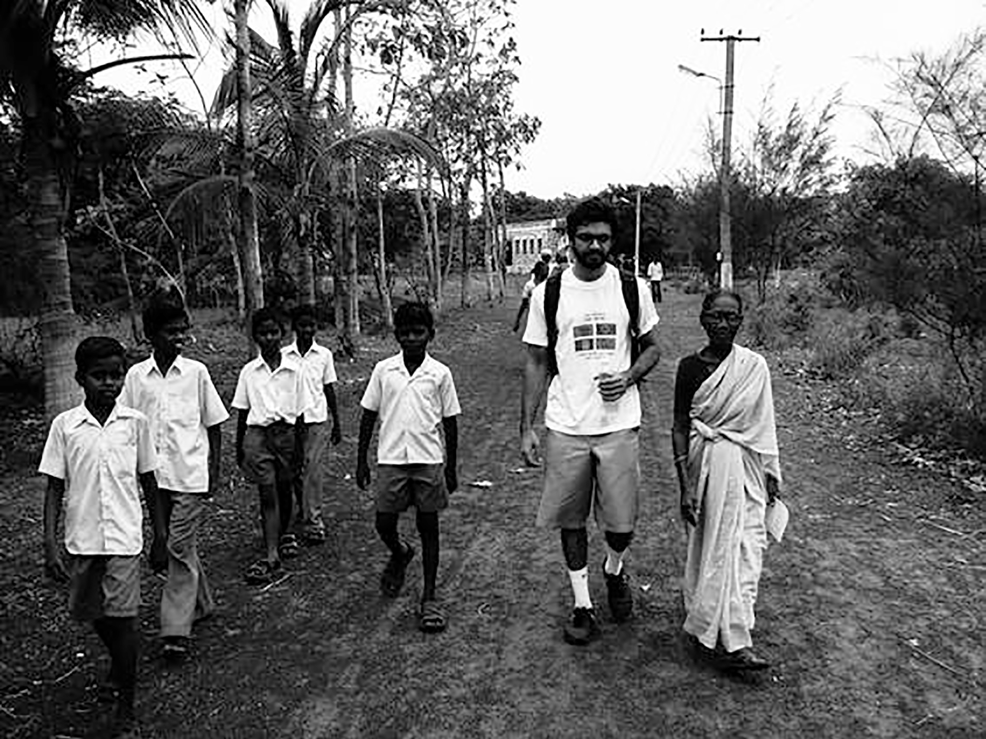 caption: On a trip to India, Abraar Karan (second from right) interviews a local woman to talk about the challenges of cataracts.