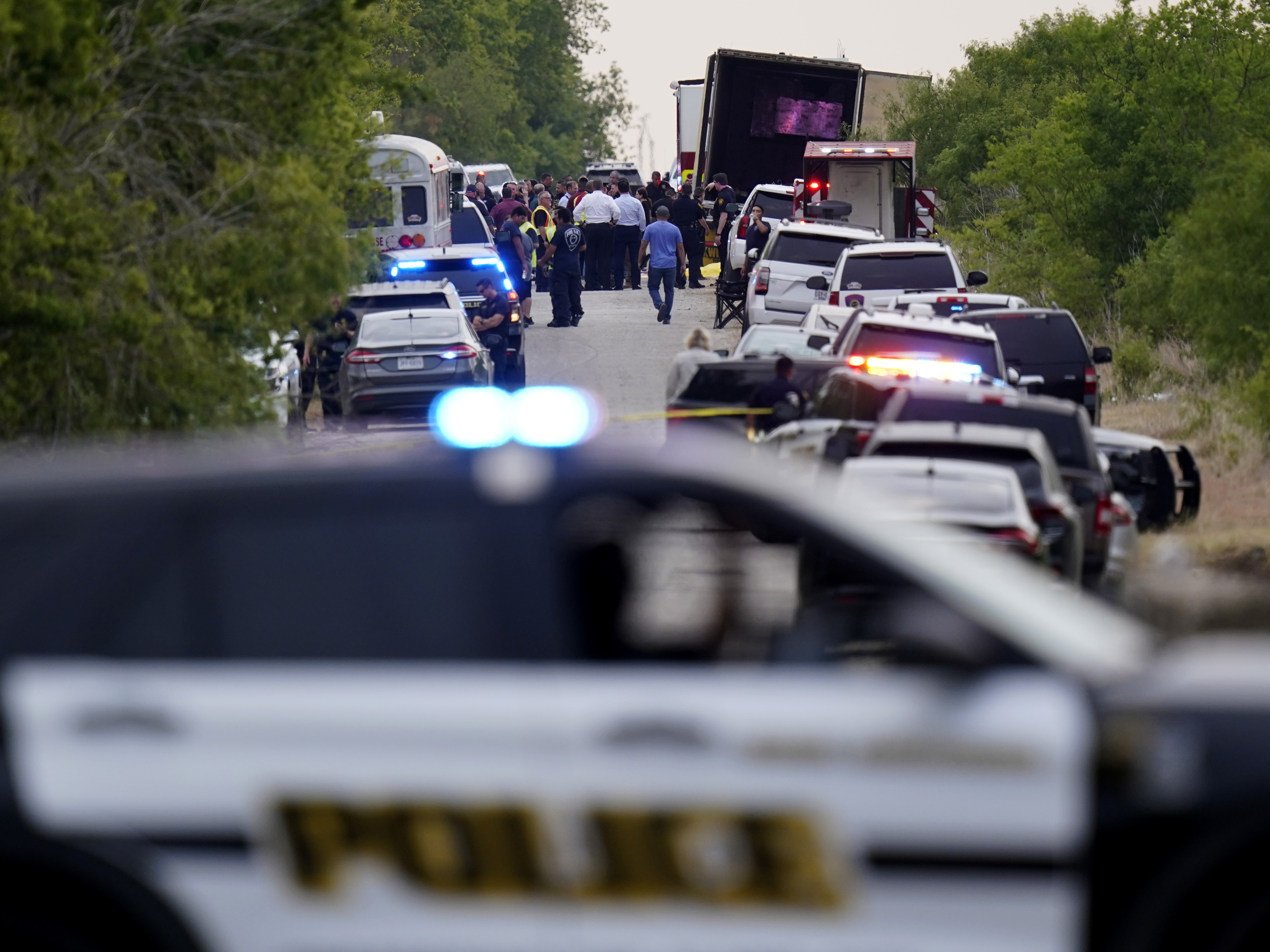 caption: Police block the scene where a semitrailer with multiple dead bodies was discovered, Monday, June 27, 2022, in San Antonio.