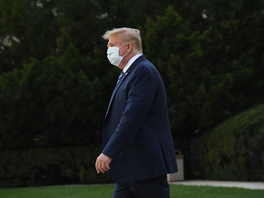 caption: President Trump leaves Walter Reed National Military Medical Center in Bethesda, Md., on Monday. He announced Tuesday he was pausing negotiations on a coronavirus relief package.