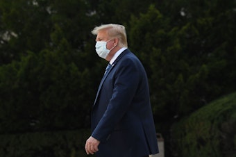 caption: President Trump leaves Walter Reed National Military Medical Center in Bethesda, Md., on Monday. He announced Tuesday he was pausing negotiations on a coronavirus relief package.