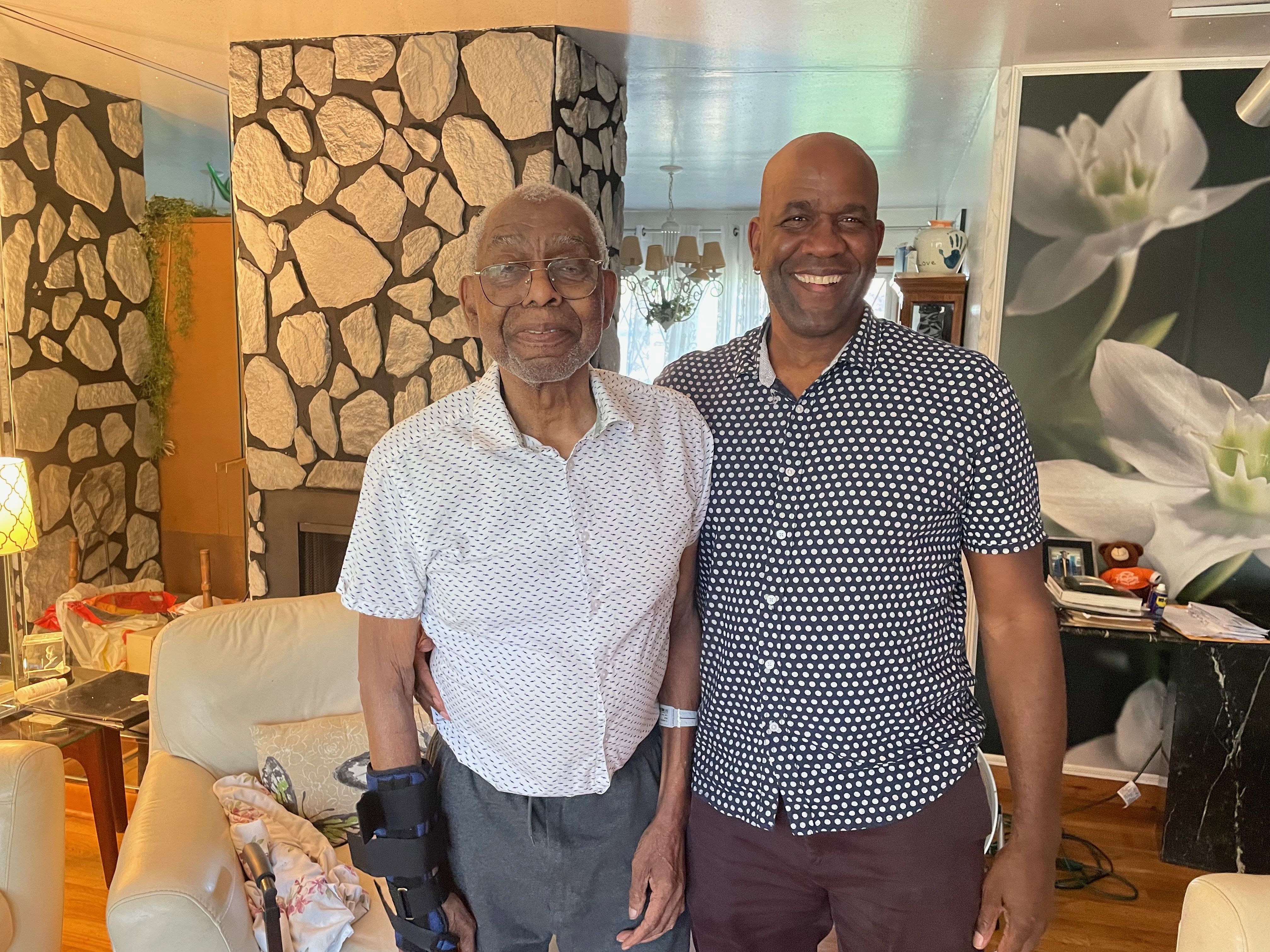 caption: Father and son are now caregiver and care recipient. Robert Turner, Sr. was cheerful even though his day started with being discharged from the hospital.