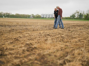 caption: Farmer Rob Stone (R) and Gregory Gingera, a canola breeder at Corteva Agriscience, walk through Stone's field in Davidson, Saskatchewan, Canada in May. Canadian farmers are looking for ways to deal with recurrent drought, including planting earlier and using seeds that are more resistant to heat.