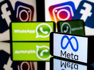 caption: This picture taken on January 12, 2023 in Toulouse, southwestern France shows a smartphone and a computer screen displaying the logos of the Instagram, Facebook, WhatsApp and their parent company Meta.
