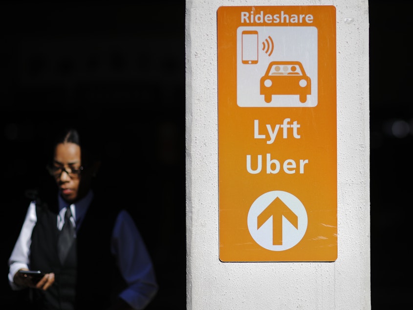 caption: A sign directs Lyft and Uber riders to a designated pickup location at Hartsfield-Jackson Atlanta International Airport in Atlanta.