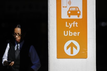 caption: A sign directs Lyft and Uber riders to a designated pickup location at Hartsfield-Jackson Atlanta International Airport in Atlanta.