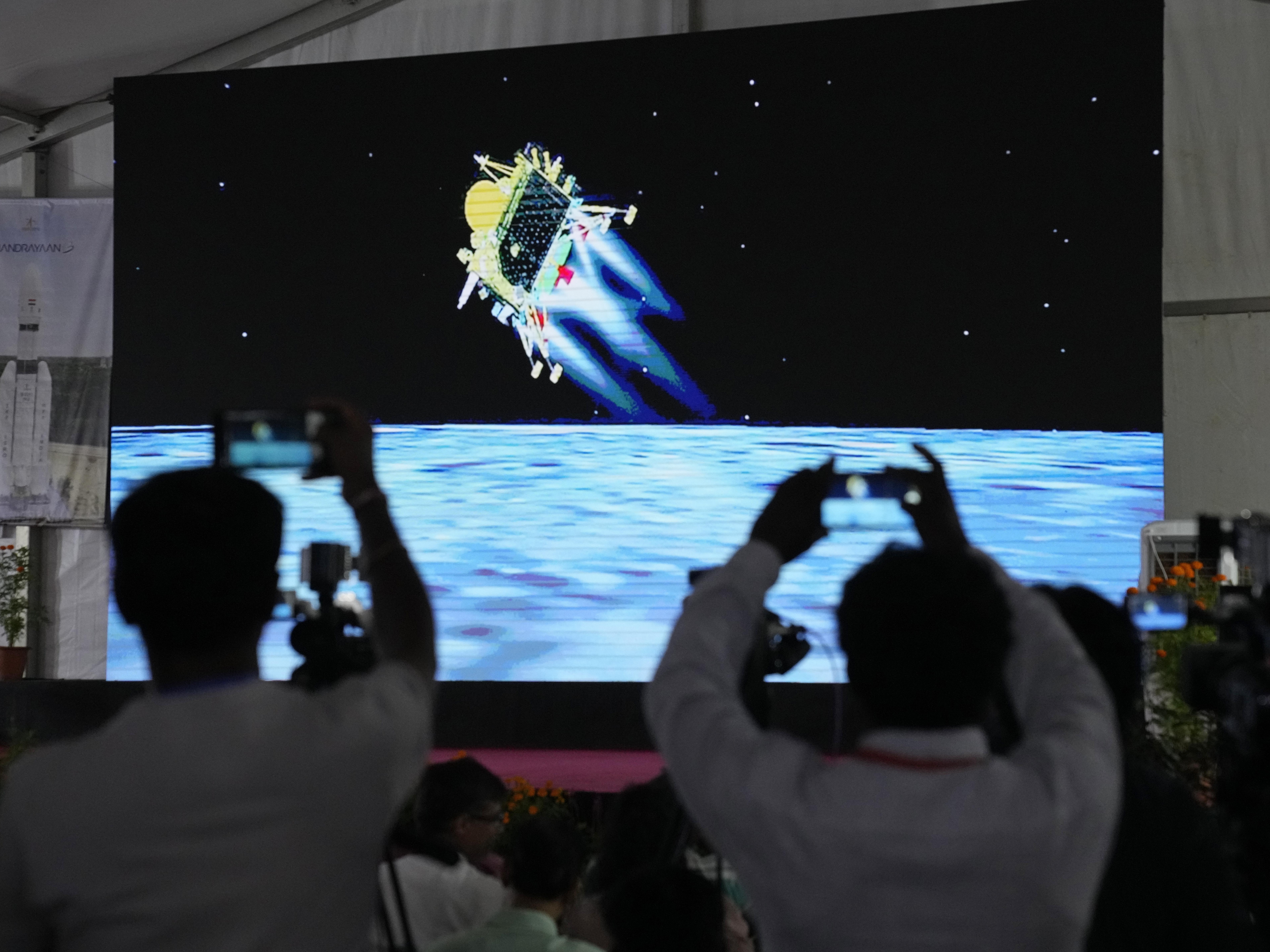 caption: Journalists film the live telecast of spacecraft Chandrayaan-3 landing on the moon at ISRO's Telemetry, Tracking and Command Network facility in Bengaluru, India, on Wednesday, Aug. 23, 2023.