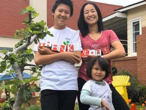 caption: Jinghuan Liu Tervalon, her son, Samuel Smookler, and daughter, Colette Liu Tervalon, in front of the family home in Altadena.