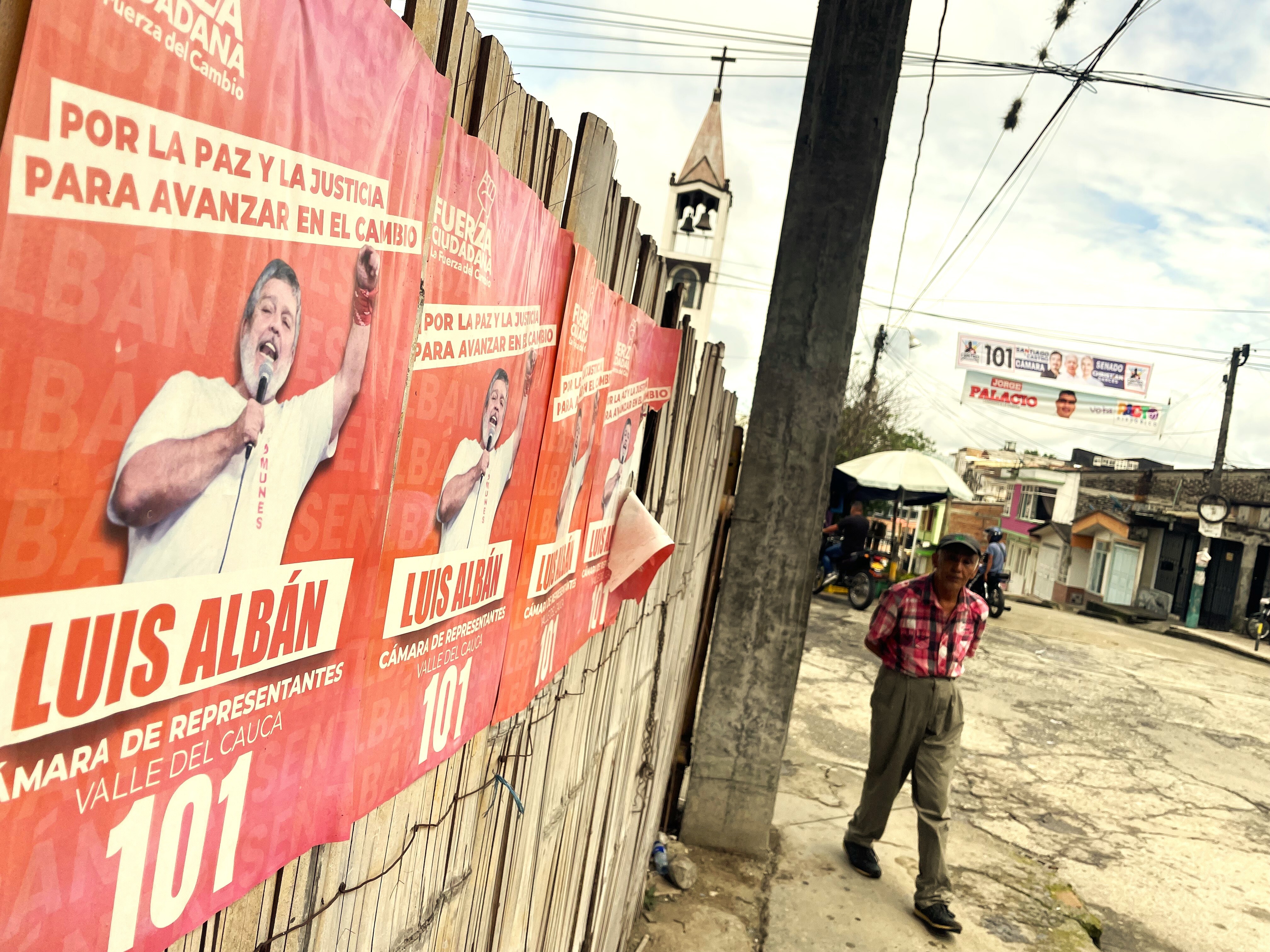 caption: Election posters for FARC candidate Luis Albán, who is campaigning for a seat in Colombia's congress on the 8th March.