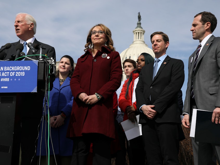caption: U.S. Rep. Mike Thompson (left), D-Calif., joined by shooting survivor and former Rep. Gabby Giffords of Arizona, holds a news conference about his proposed gun background check legislation, on Capitol Hill on Tuesday.