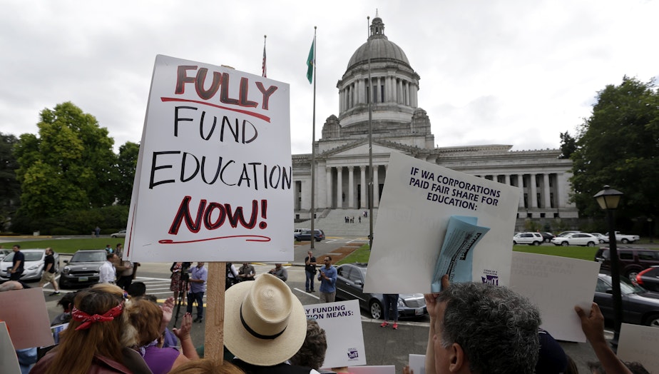 caption: Demonstrators on the steps of the Temple of Justice advocate for more state spending on education, Sept. 3, 2014, in Olympia. The court ordered lawmakers to explain why they haven't followed its orders to fix the way Washington pays for public education. 