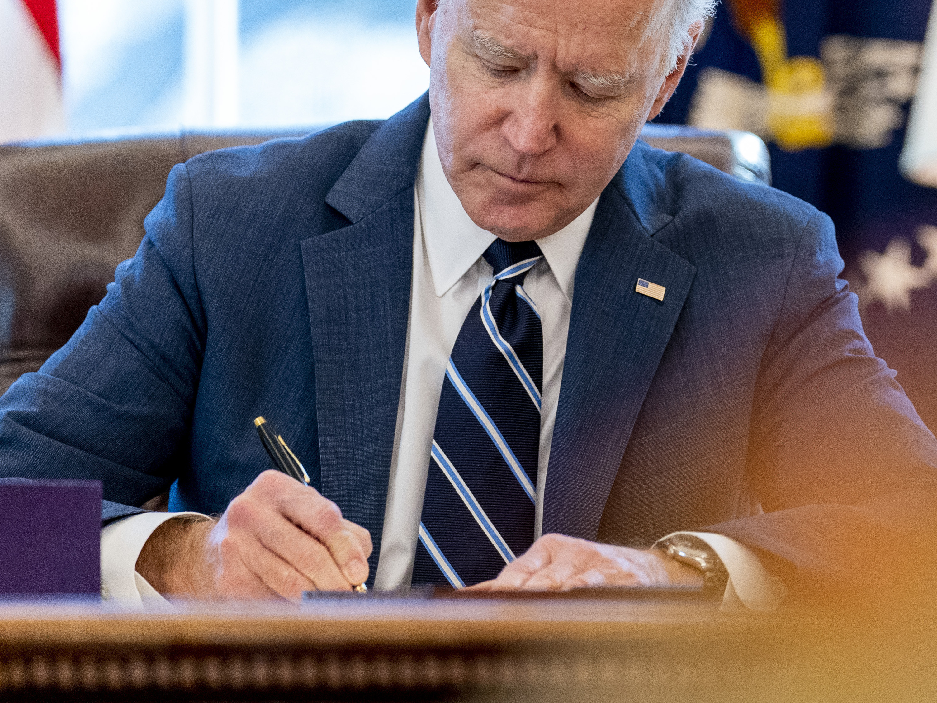 caption: President Biden signs the American Rescue Plan in the Oval Office of the White House on Thursday. Included in the plan is a monthly allowance for many American families that could be a potential financial-life-changer.