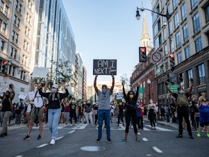 caption: Demonstrators in Washington, D.C., on Sunday hold signs as they protest the death of George Floyd.