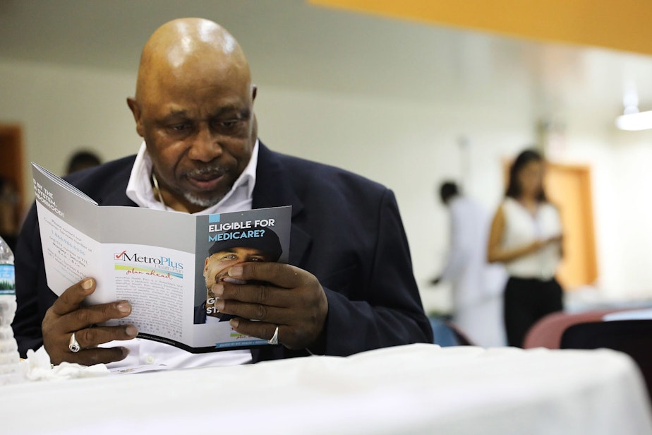 caption: A man reads literature on Medicare at an event sponsored by MetroPlus, a prepaid health services plan, on June 23, 2017 in New York City. The Harlem seniors were provided with Medicare education and health care options at the event. (Spencer Platt/Getty Images)