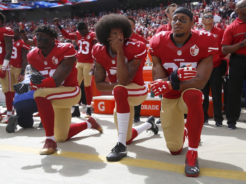 caption: From left, Eli Harold (58),  Colin Kaepernick (7) and Eric Reid (35) kneel during the national anthem before their NFL game against the Dallas Cowboys on Sunday, Oct. 2, 2016.