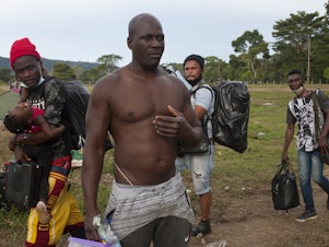 caption: Gegrand Joseph (front), a Haitian who hiked across the Darién Gap five years ago, was deported by the Trump administration and is tackling this same patch of jungle a second time to get back to the U.S.