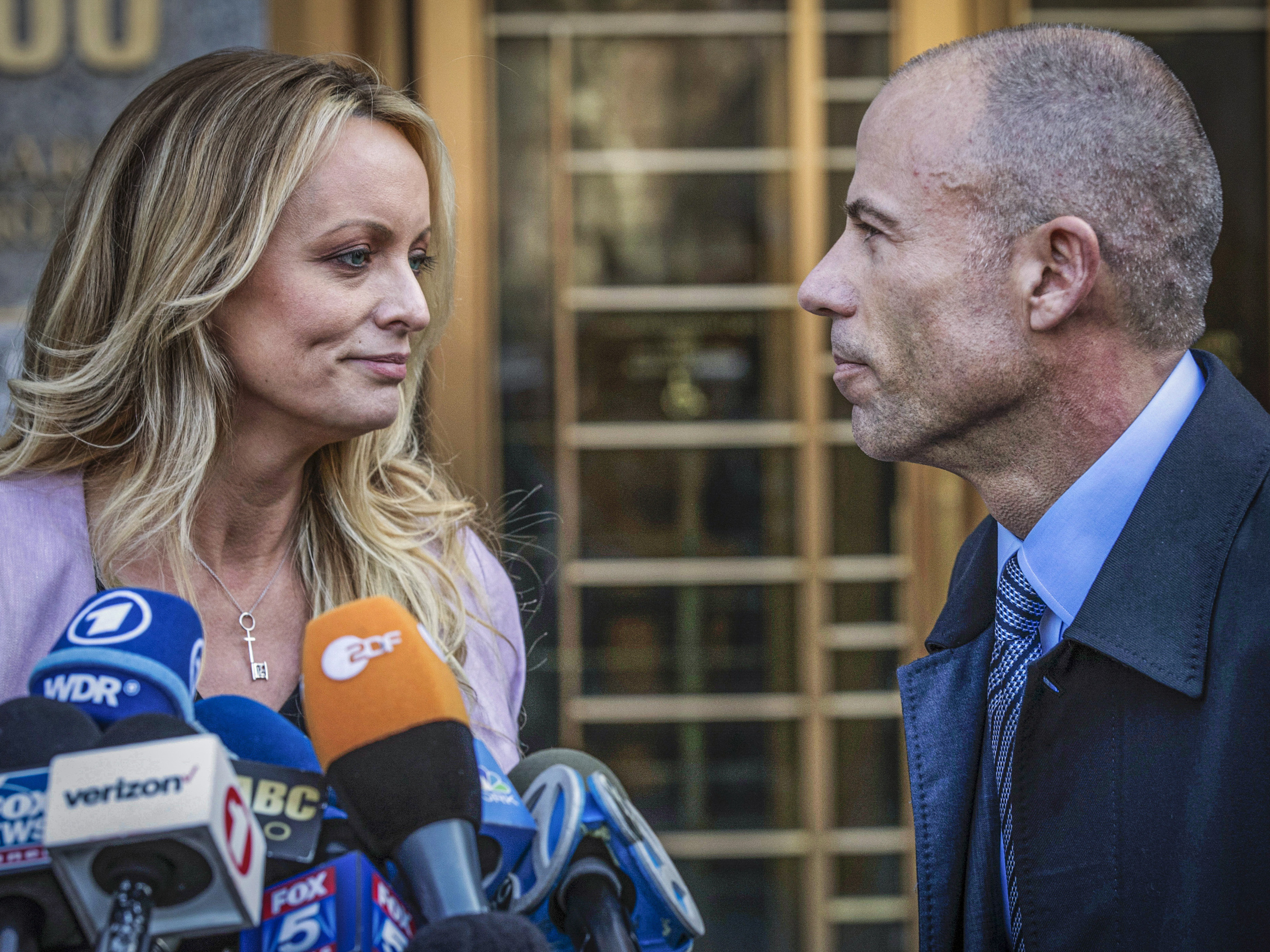 caption: Adult film actress Stormy Daniels stands with her lawyer Michael Avenatti during a news conference outside federal court in New York on April 16, 2018. Avenatti was convicted Friday on charges that he cheated Daniels out of nearly $300,000.
