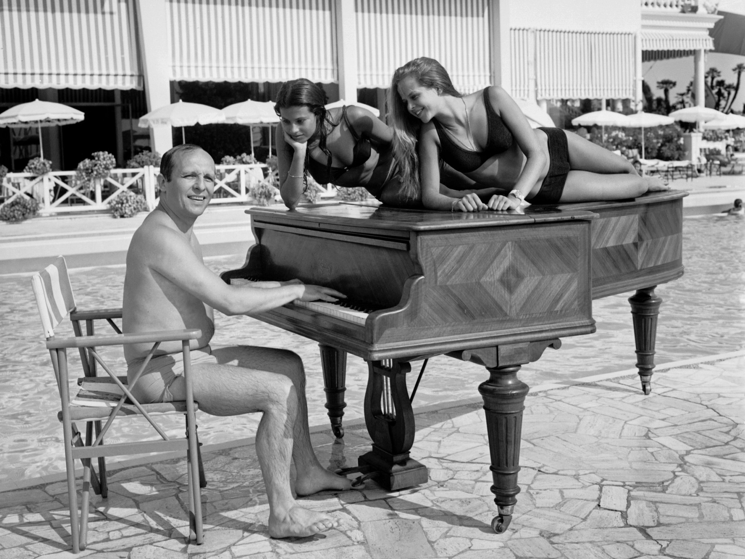 caption: A shot of jazz pianist Claude Bolling and friends, taken on a beach in Cannes, France in 1969.