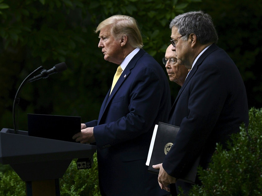 caption: President Trump, flanked by Commerce Secretary Wilbur Ross (back) and U.S. Attorney General William Barr, delivers remarks on citizenship data in the Rose Garden at the White House in Washington, D.C., in July.