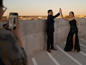 caption: Eddie Almance (left) and his sister Leila pose for their cousin Ailem Villarreal on the rooftop of the Marriott Hotel in downtown Odessa, Texas, before heading to prom. Their grandmother says that for seven generations, the family members have forged close bonds.