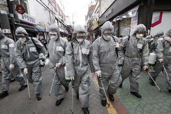caption: Korean soldiers spray disinfectant as a precaution against the coronavirus on a shopping street in Seoul, South Korea, last week. U.S. military stationed in South Korea and Italy have been ordered not to travel because of the outbreak.