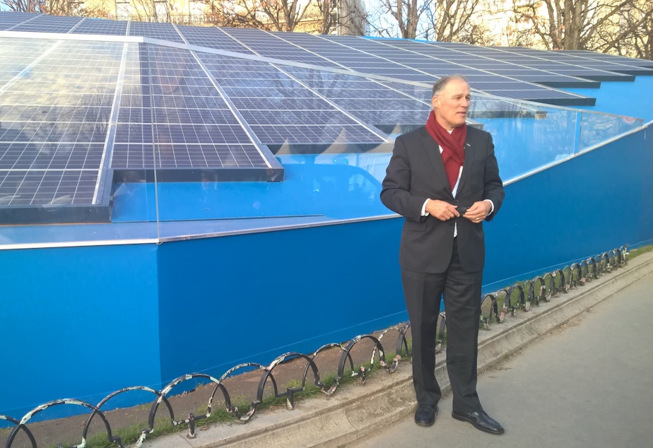 caption: Washington Gov. Jay Inslee, one of the 'super-nationals,' with a solar installation in Paris. 
