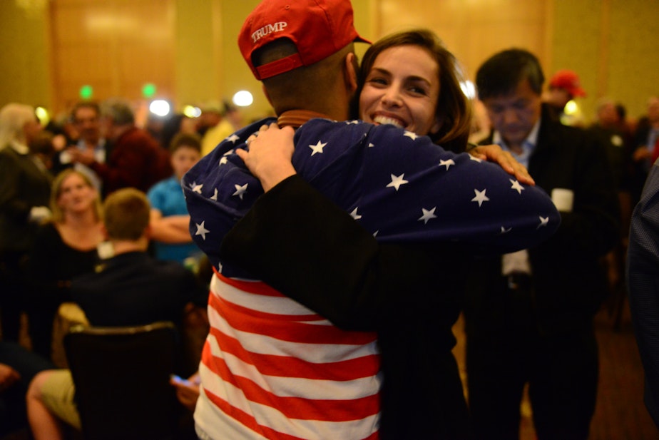 caption: Friends hug at the Republican watch party on Tuesday night in Bellevue.