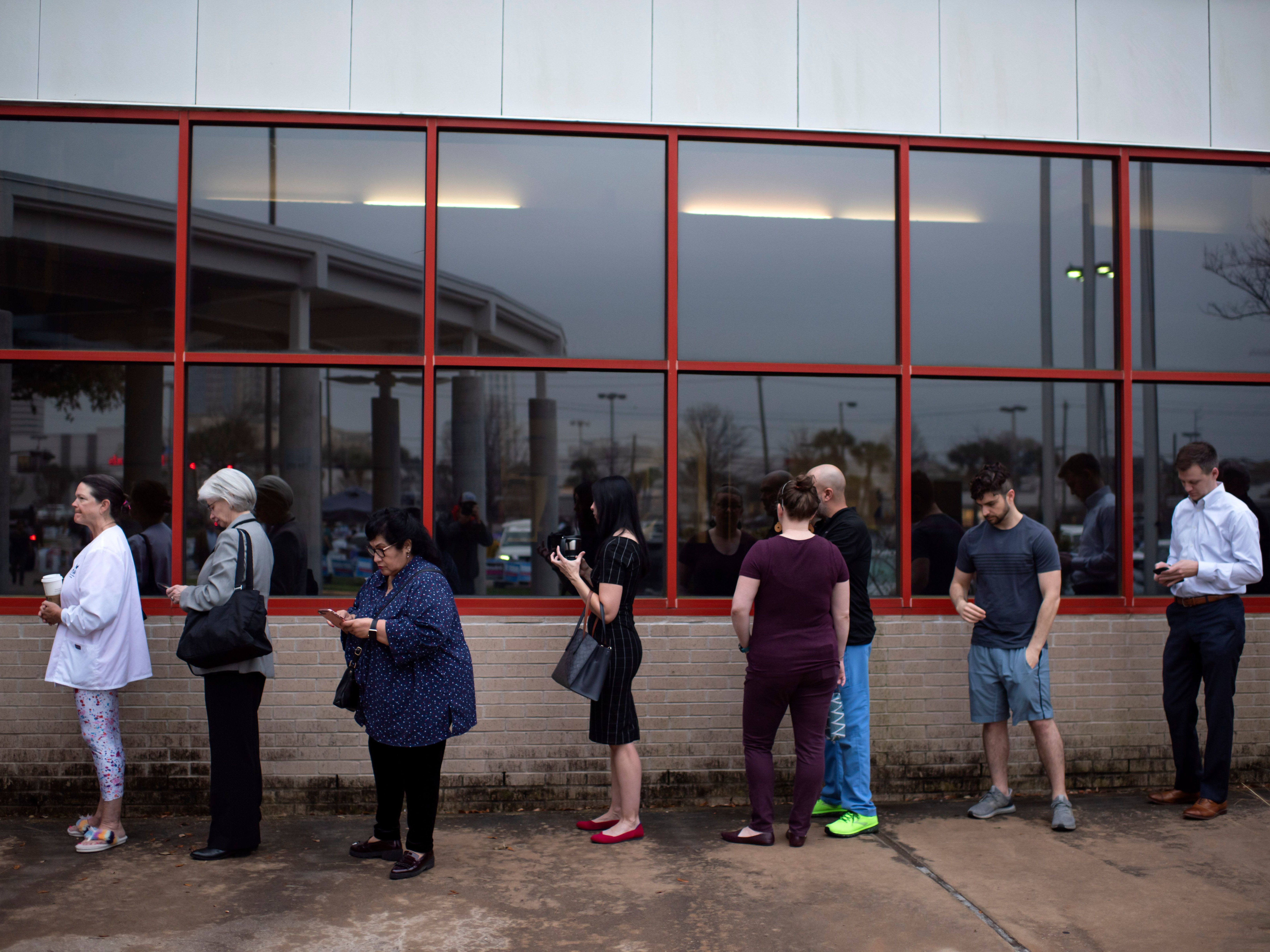 caption: Voters wait in line to cast their ballots during the presidential primary in Houston, Texas on Super Tuesday, March 3.