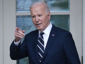 caption: President Biden walks to the Oval Office from the Rose Garden on May 14.