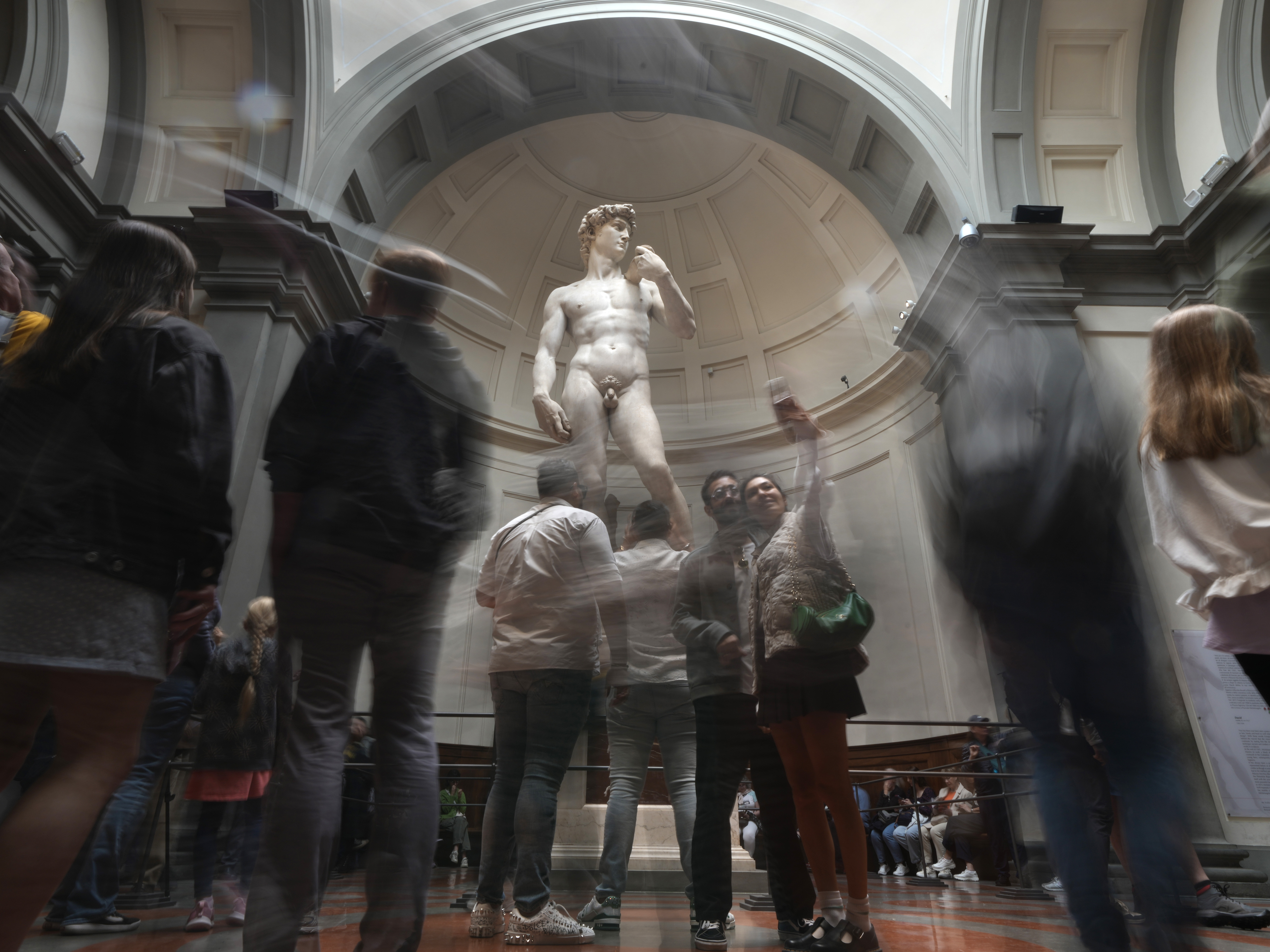 caption: Tourists take photos in front of Michelangelo's David in the Accademia Gallery in Florence, Italy, on Tuesday. The Florence museum and the city's mayor are inviting parents and students from the Florida charter school to visit and see Michelangelo's sculpture in person.