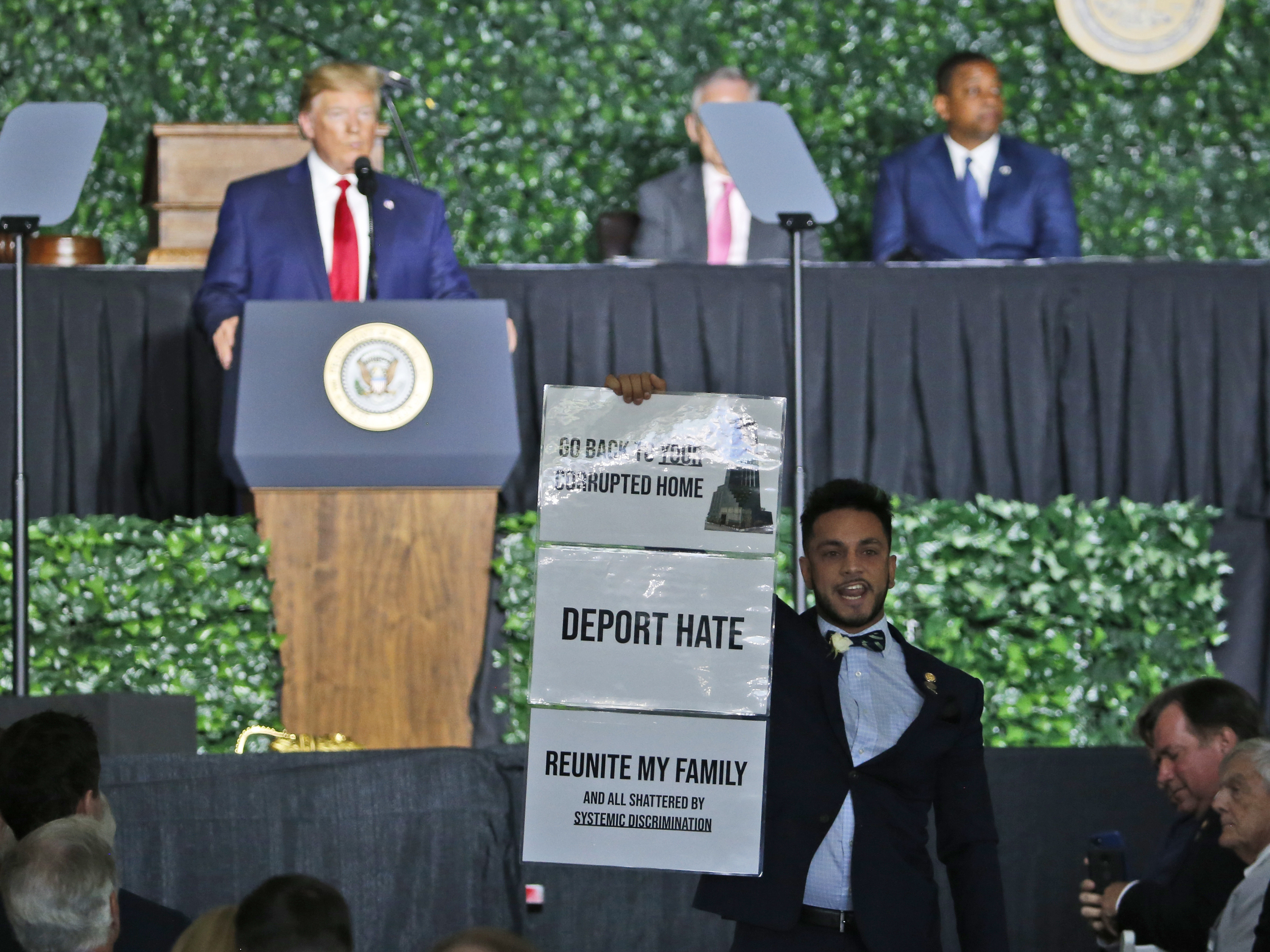 caption: A protester, Virginia Del. Ibraheem Samirah, D-Fairfax, interrupted President Trump at a commemorative meeting of the Virginia General Assembly in Jamestown, Va.
